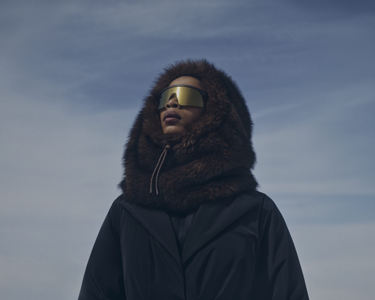Model in a black faux fur-trimmed hood and mirrored gold visor, H&M MOVE campaign by Casper Sejersen