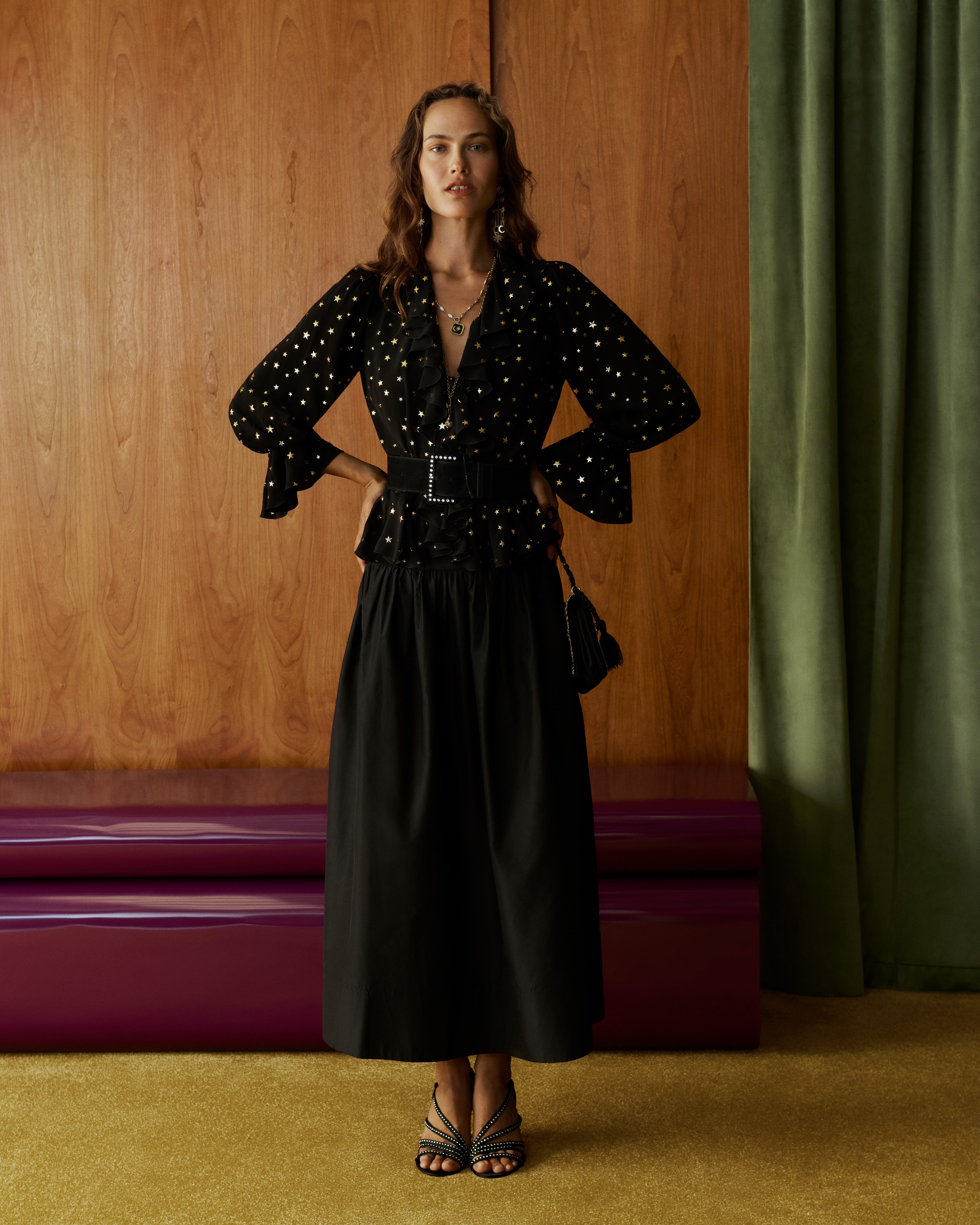 Model in a black polka-dot ruffle blouse with flared cuffs and a black maxi skirt from John Lewis x RIXO